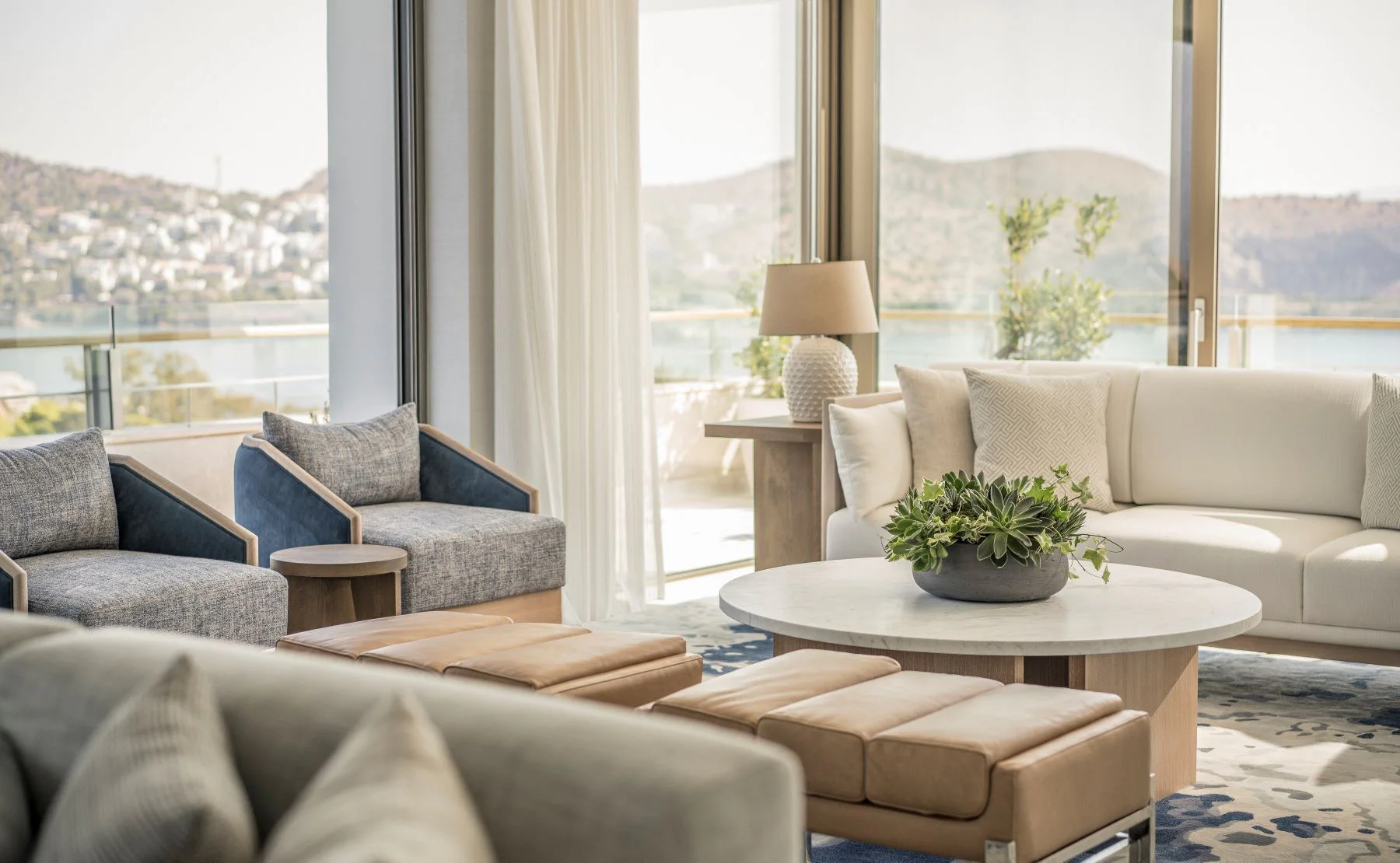 Light-filled Four Seasons suite living room with broad views across Vouliagmeni Bay