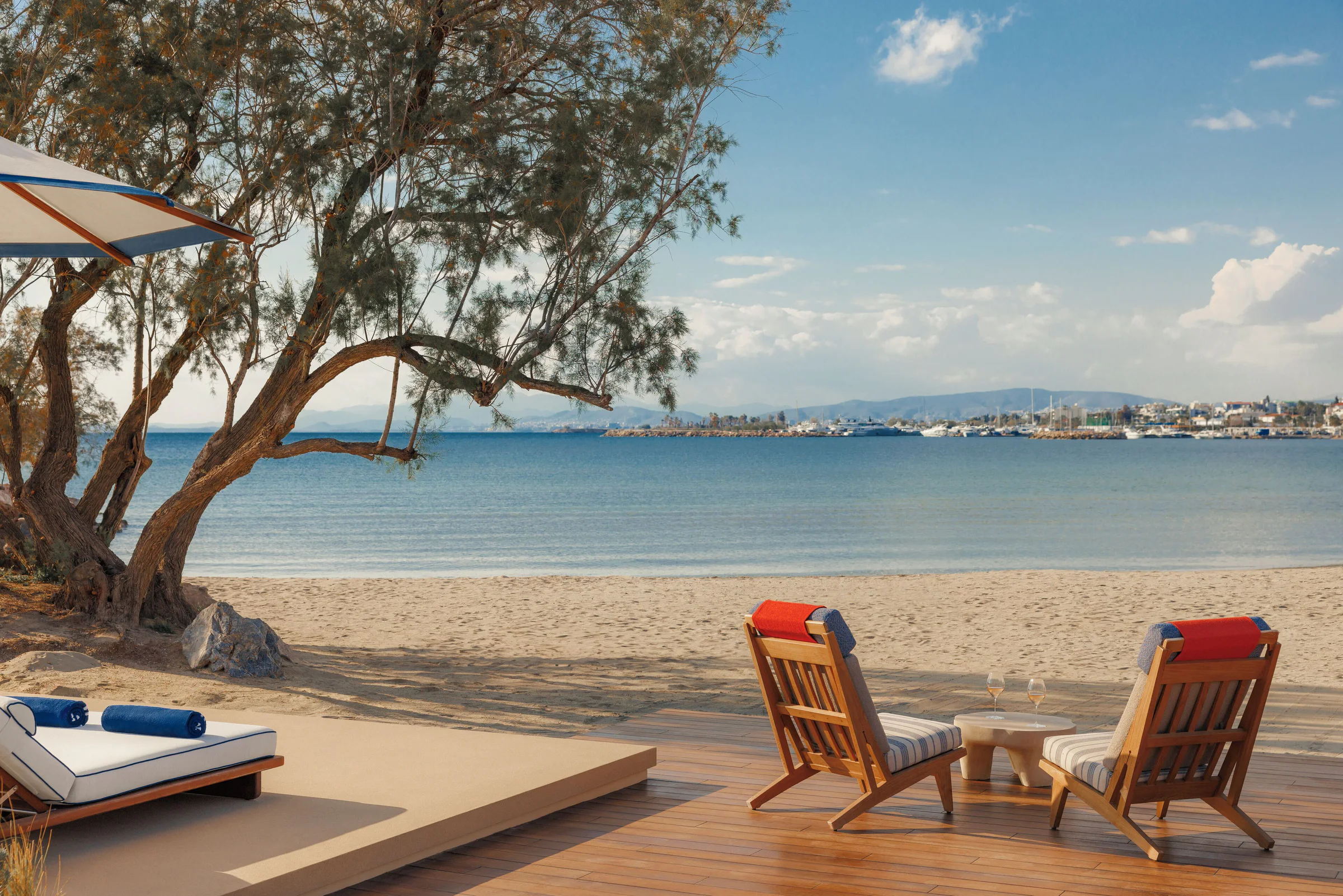 Shaded beachfront terrace with loungers overlooking the calm Saronic Gulf