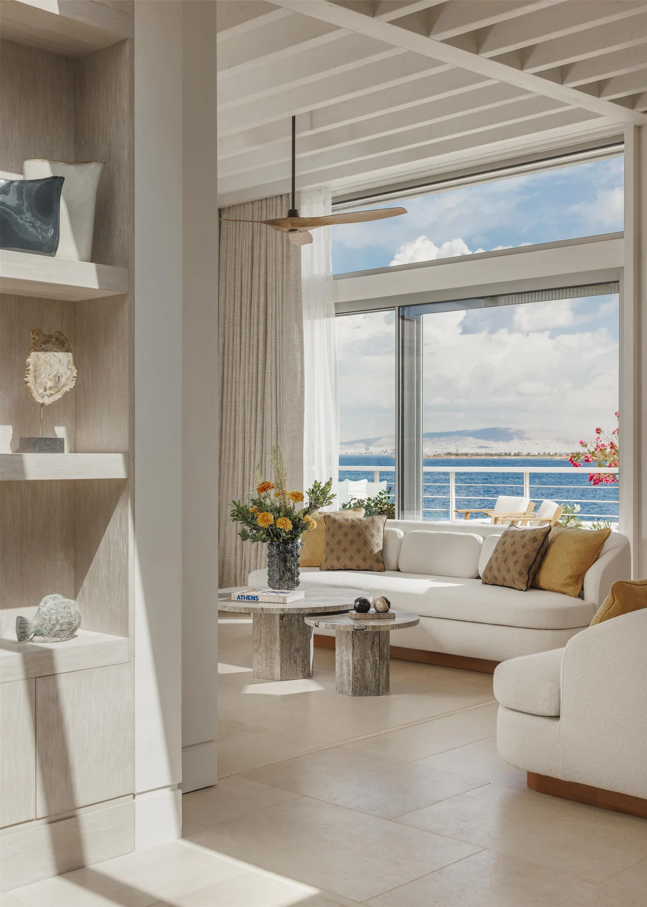 Bright suite living room framed by a balcony and views across Glyfada bay