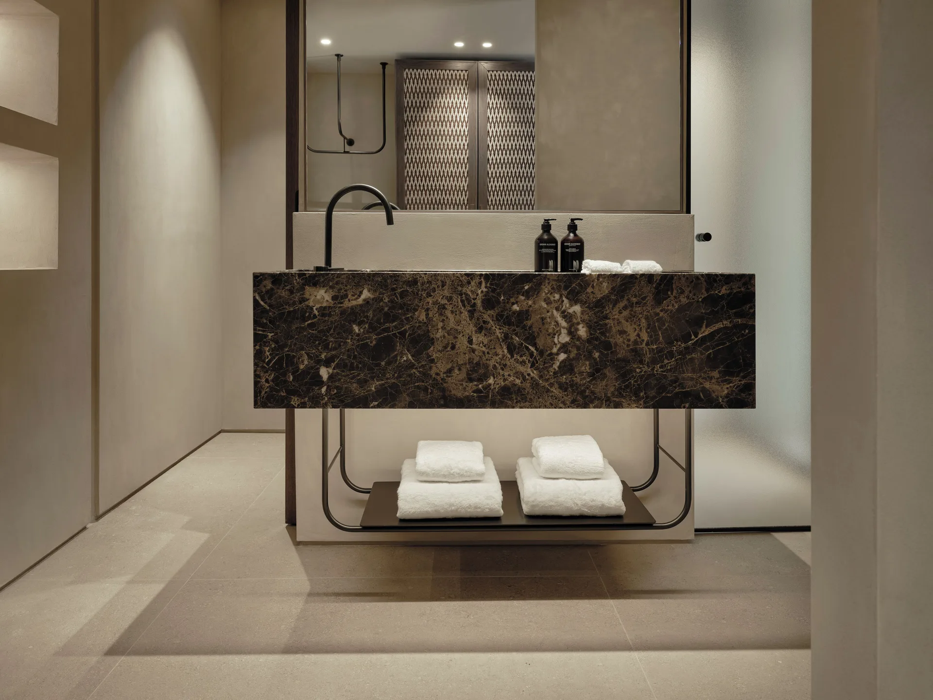 Floating dark marble vanity and softly lit mirrors in an Oroséa suite bathroom