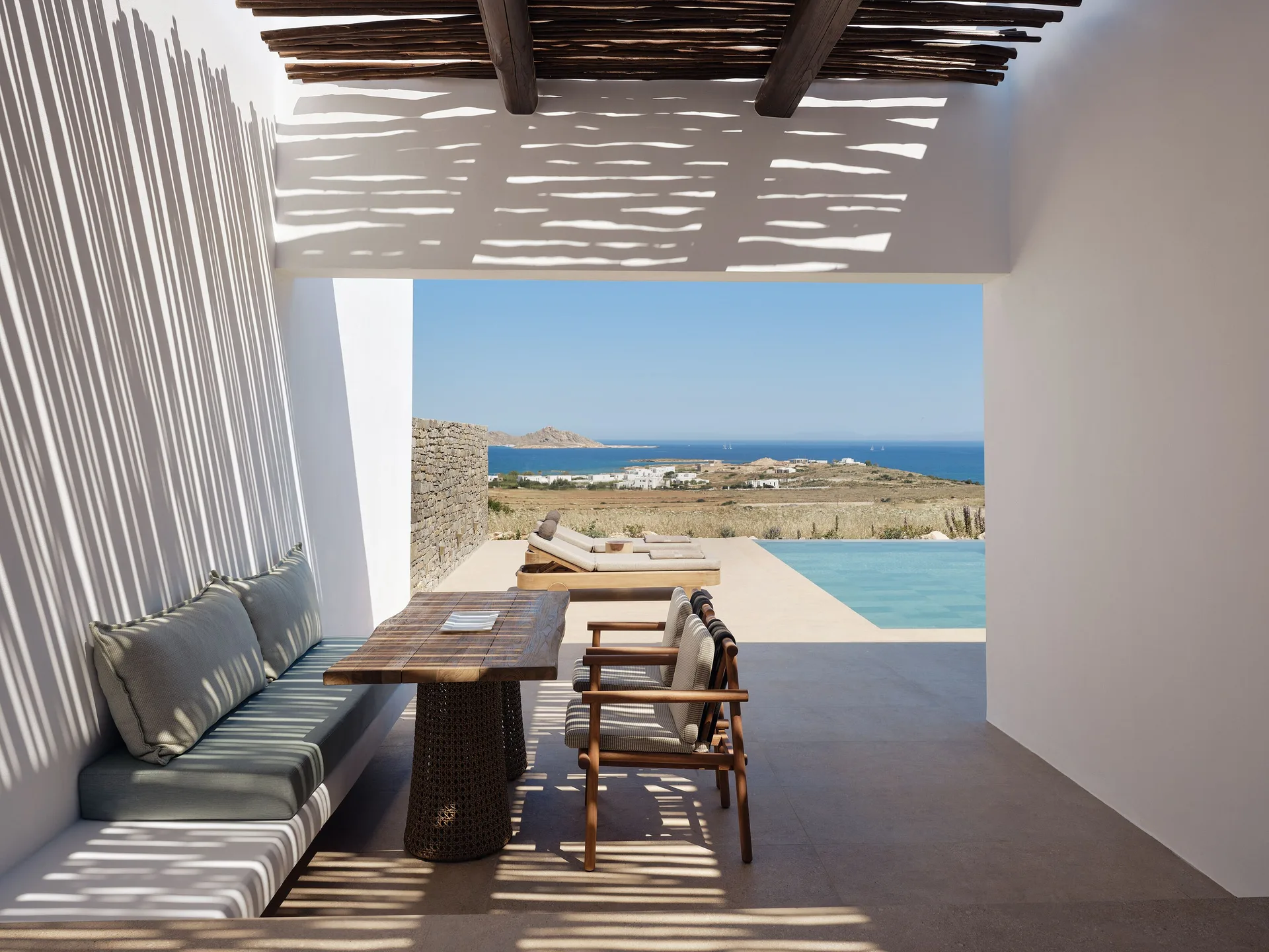 Shaded suite terrace and private pool looking across the fields and sea near Naoussa