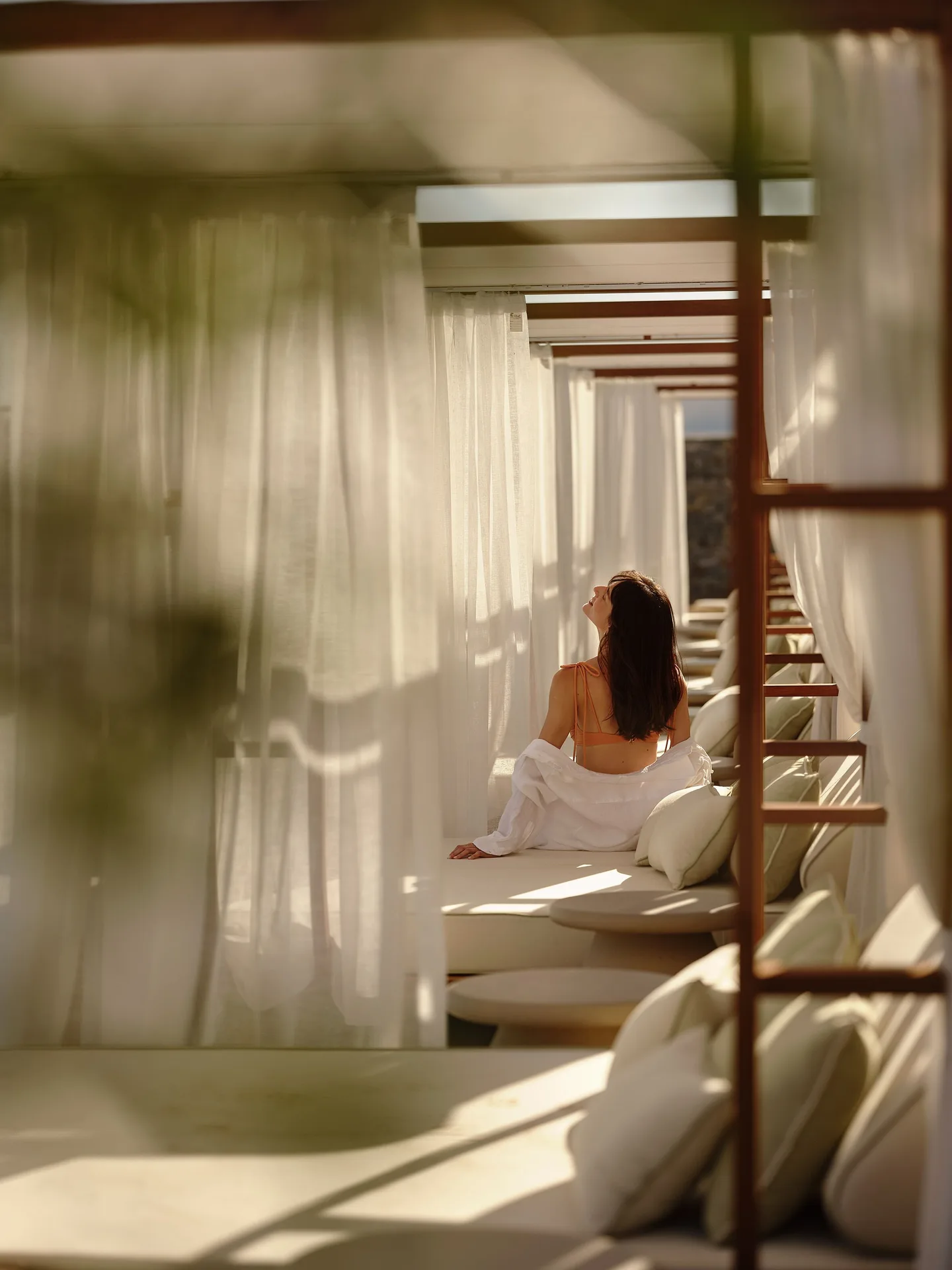 Sunlit pool cabana with sheer curtains and cushioned daybeds at the adults-only hotel