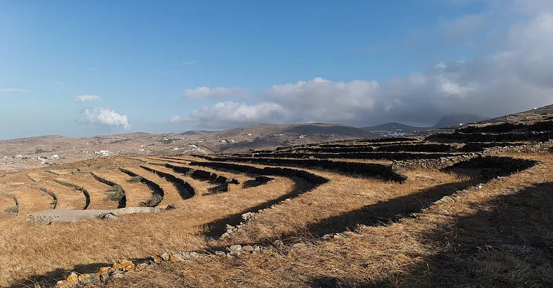 A whitewashed Tinos village surrounded by terraces and Aegean light